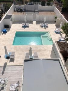 uma vista sobre uma piscina com espreguiçadeiras em B&B Alto Salento - Pool and Sun em Pulsano