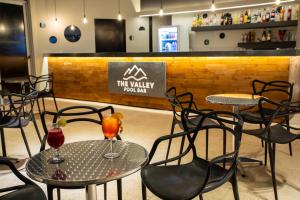 dwa stoły i krzesła z drinkami w restauracji w obiekcie Pinares del Cerro Resort & Suites w mieście Villa Carlos Paz