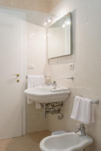 bagno bianco con lavandino e servizi igienici di Il Tacco Dello Stivale a Lecce