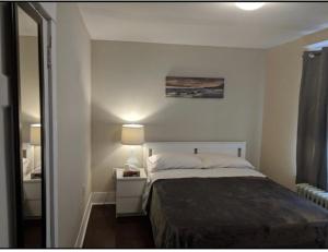 a small bedroom with a bed and a mirror at House in Niagara falls, Close to Clifton Hill, Casino and Horseshoe falls and with kitchen for 6 Guest in Niagara Falls