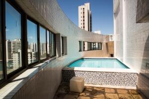 a swimming pool on the side of a building with windows at Melhor local da zona norte Sem Taxas in Recife
