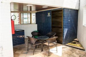 a table and chairs in a room with blue tiles at Melhor local da zona norte Sem Taxas in Recife