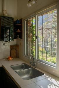 a kitchen with a sink and two windows at Casa de campo La Brea in San Fernando del Valle de Catamarca
