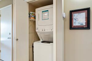 a small laundry room with a washer and dryer at Maui Banyan H311 1BD 2BA 3 min walk to the beach in the Heart of South Kihei! in Wailea