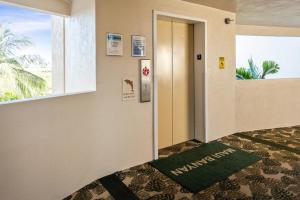 a hallway with a door and a window and a green rug at Maui Banyan H311 1BD 2BA 3 min walk to the beach in the Heart of South Kihei! in Wailea