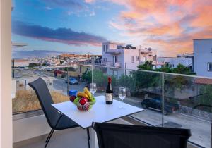 a table with a bottle of wine and a bowl of fruit at Vakakis Family Luxury Studios 2 in Palaiochóra