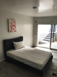 sypialnia z łóżkiem i dużym oknem w obiekcie 5 bedroom 3 bath home near universal w mieście Sherman Oaks