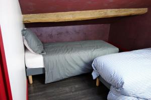 a small room with two beds in a room at Couleurs du Daumail in Saint-Priest-sous-Aixe