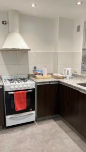 a kitchen with a stove and a red towel on the oven at Administración MAIPU PB B Depto Premium in Tandil