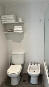 a white bathroom with a toilet and a sink at Administración MAIPU PB B Depto Premium in Tandil