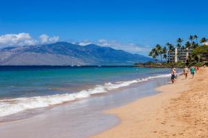 a group of people walking on the beach at Maui Banyan H311 1BD 2BA 3 min walk to the beach in the Heart of South Kihei! in Wailea