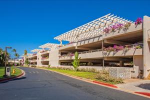 an apartment building with flower boxes on the balconies at Maui Banyan H311 1BD 2BA 3 min walk to the beach in the Heart of South Kihei! in Wailea