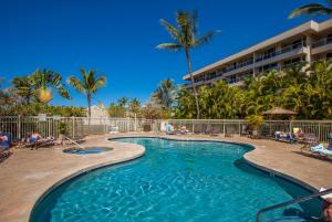 a swimming pool at a resort with palm trees at Maui Banyan H311 1BD 2BA 3 min walk to the beach in the Heart of South Kihei! in Wailea