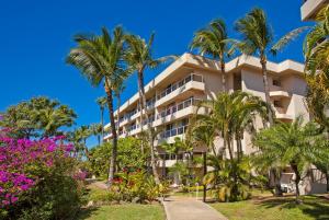a resort building with palm trees and flowers at Maui Banyan H311 1BD 2BA 3 min walk to the beach in the Heart of South Kihei! in Wailea