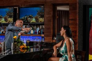 Un uomo che serve a una donna un bicchiere di vino in un bar di Costa d'Este Beach Resort & Spa a Vero Beach