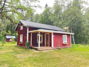 una pequeña casa roja con un porche en un patio en HomeSweetSweden en Malung