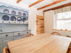 a kitchen with a wooden table and chairs at Tinmans Cottage in Lydbrook