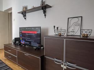 een woonkamer met een tv op een dressoir bij Apartman Sabah in Novi Pazar