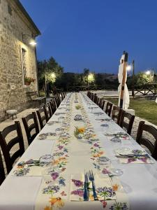 a long table with plates and napkins on it at Agriturismo Torre Gialluise in Gesualdo