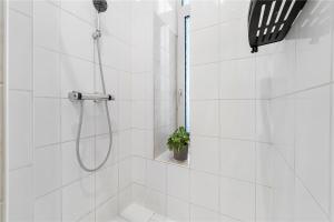 a white bathroom with a shower with a plant in it at Holiday 33 Apartment I Mitte in Berlin