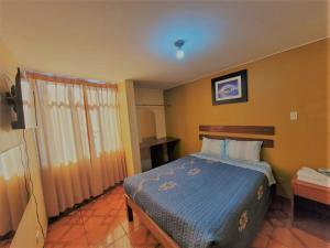 1 dormitorio con 1 cama con edredón azul en Hostal Cristal de luna, en Arequipa