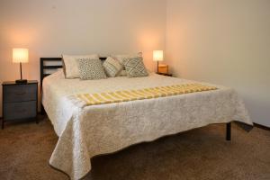 a large bed in a room with two lamps at Idlewild Pines Retreat in Rapid City