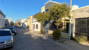 a street with cars parked on the side of the road at Altos San Martín in Concepción del Uruguay