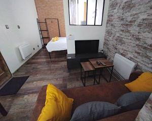 - un salon avec un canapé et un lit dans l'établissement LE FACTORY Studio industriel Bourges Hyper centre, à Bourges