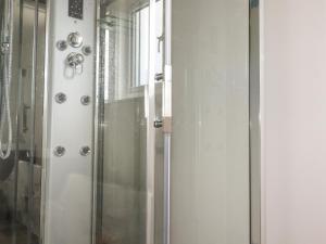 a shower with a glass door next to a window at Atlantic Apartment in Bude +5 photos