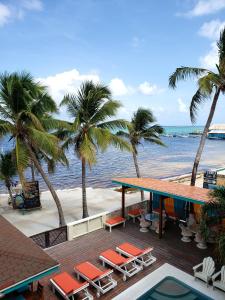 een uitzicht op een strand met palmbomen en een tafel en stoelen bij Ocean Tide Beach Resort in San Pedro