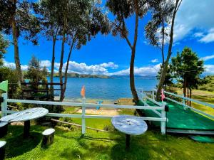 a bench with a view of the water at La Puerta Del Lago ECOPARQUE in Tota