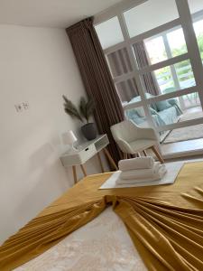 een slaapkamer met een bed met een stoel en een raam bij Golden Coast Residence in Portimão