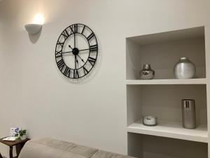 um relógio numa parede numa sala de estar em Casa Patrito - Appartamento Barolo em Barolo
