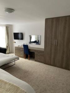 ボーンマスにあるDurley Grange Hotelのベッドルーム1室(ベッド1台、ドレッサー、デスク付)