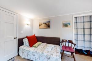 a small bedroom with a bed and a chair at Beach Rose Guest Studio in Nauset Heights