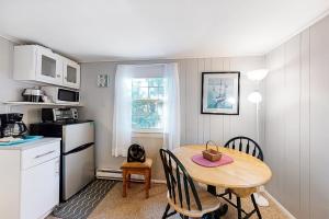 a small kitchen with a table and a refrigerator at Beach Rose Guest Studio in Nauset Heights