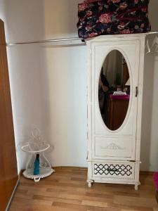 a white cabinet with a mirror in a room at Mitten in Düsseldorf in Düsseldorf