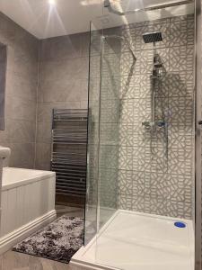 a bathroom with a shower with a glass door at Pleasure Beach View in Blackpool