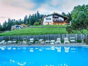 ein Haus auf einem Hügel mit Pool in der Unterkunft Schliersberg Alm in Schliersee
