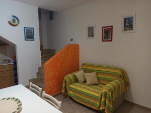 - un salon avec une chaise et un canapé dans l'établissement Casa Gialla, à Torre Pali