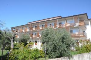 an apartment building with balconies and trees at Elaia Garden Hotel in Sperlonga