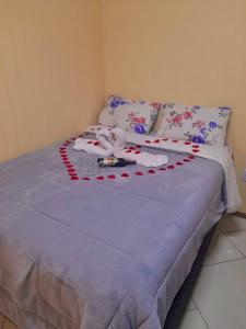 a bed with red and white decorations on it at Apartamento Cambara com churrasqueira e uma ampla sacada in Cambara do Sul