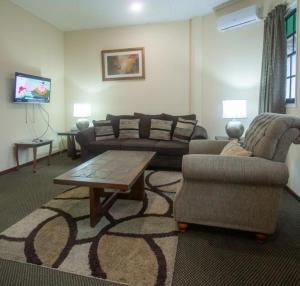 a living room with a couch and a coffee table at The Golden Truly Hotel & Casino in Paramaribo