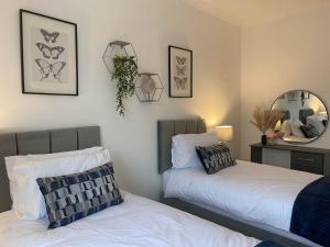 two beds sitting next to each other in a bedroom at The Retreats 2 Kenfig Hill Pet Friendly 2 Bedroom Flat with King Size bed twin beds and sofa bed sleeps up to 5 people in Kenfig Hill +15 photos
