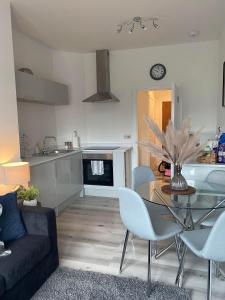 a living room and kitchen with a glass table and chairs at The Retreats 2 Kenfig Hill Pet Friendly 2 Bedroom Flat with King Size bed twin beds and sofa bed sleeps up to 5 people in Kenfig Hill