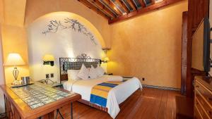 een slaapkamer met een bed en een tafel in een kamer bij Hotel Boutique Casona de la China Poblana - Adults Only in Puebla