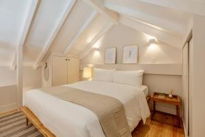 a bedroom with a large white bed and a table at D&S - JB Apartments in Porto