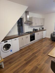 a kitchen with white cabinets and a washer and dryer at Waterdale Lodge in Galway