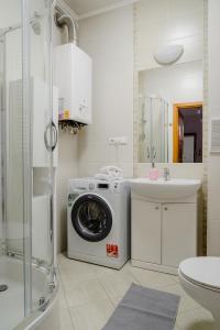 a bathroom with a washing machine and a sink at Warsaw Concierge Racławicka in Warsaw
