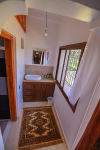 ein Bad mit einem Waschbecken und einem Fenster in der Unterkunft Kasbah Roseville in Aït Ouahi